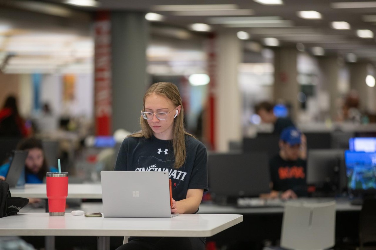 A UC student studying for the GRE in Langsam Library on campus