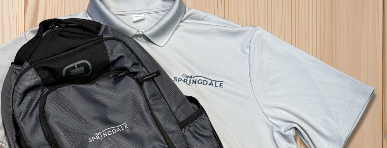 A polo shirt and backpack featuring the new City of Springdale logo