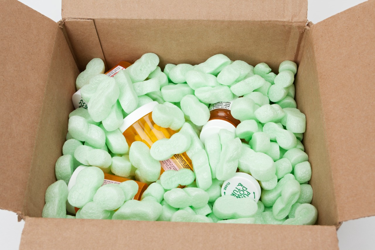 Box full of styrofoam peanuts and medicine bottles