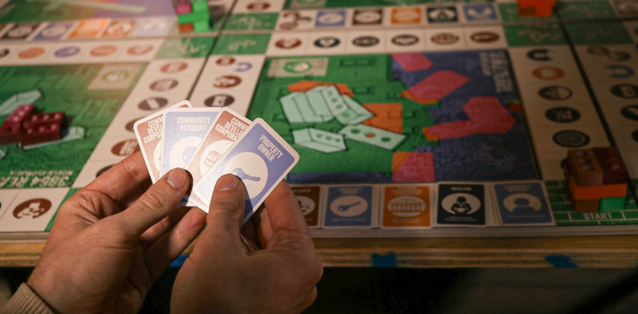 board game with player holding cards 