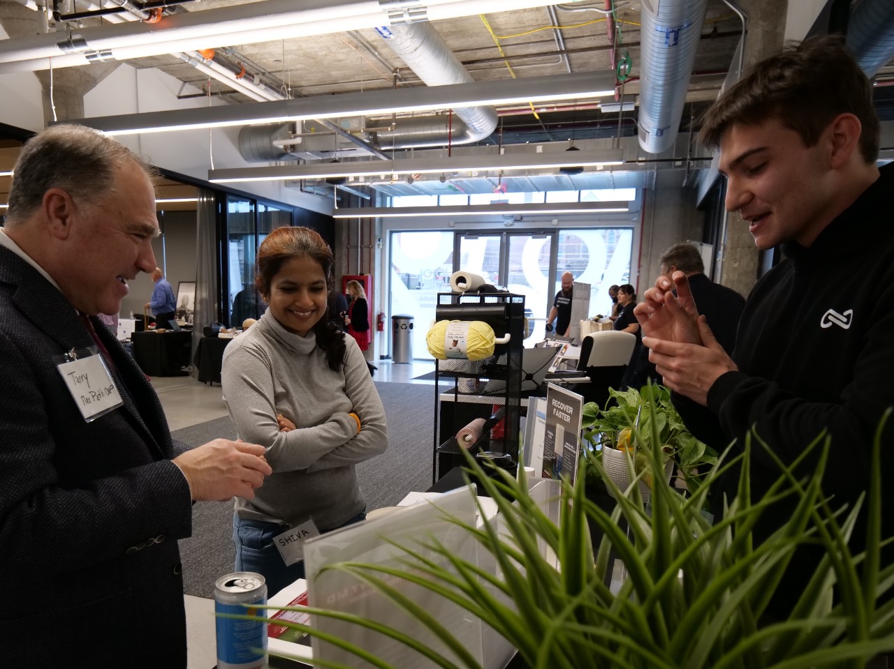 Attendees speak with presenters during Venture Lab's demo day at the 1819 Innovation Hub.