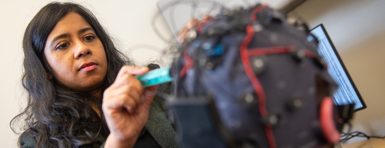 Ishita Basu works on a headpiece covered with electrodes in her lab