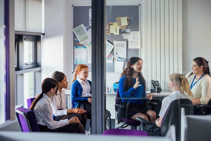 school age children in an office talking to the counselor