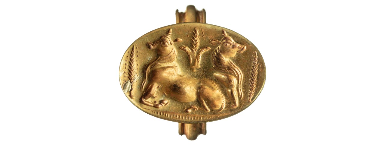 A golden ring depicts two bulls and wheat. 