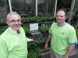 Dean Greg Sojka and Warren Walker, district manager of Community and Government Relations with Duke Energy, check out the progress of plants in the green house that will be planted in the Community Garden.