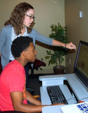 Gen-1 House Director Christina Black shows thrid-year student Ian Jackson how to use lynda.com to enhance his media image files in the residence computer room 10-7-14.