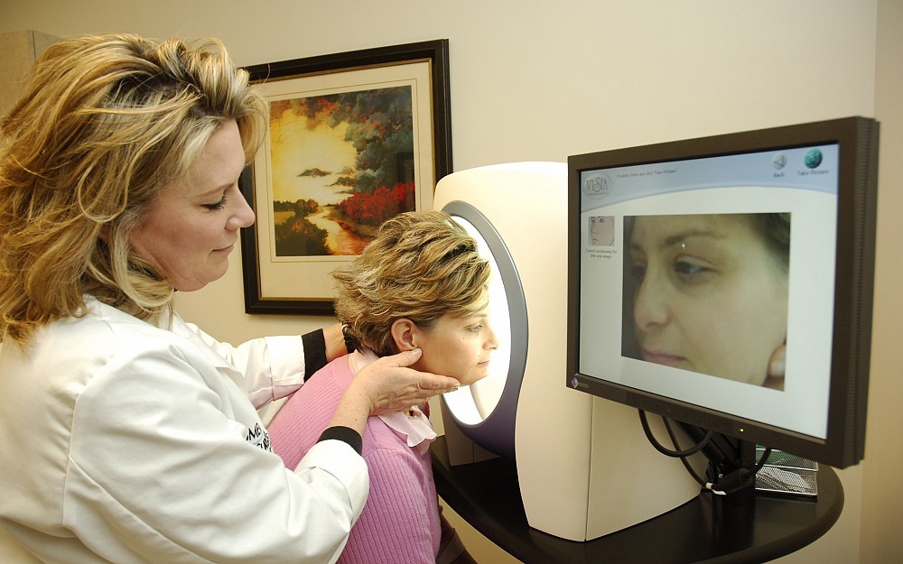 Medical skin care specialist Cathy Fricke conducts a skin analysis on Stacie Cooper.