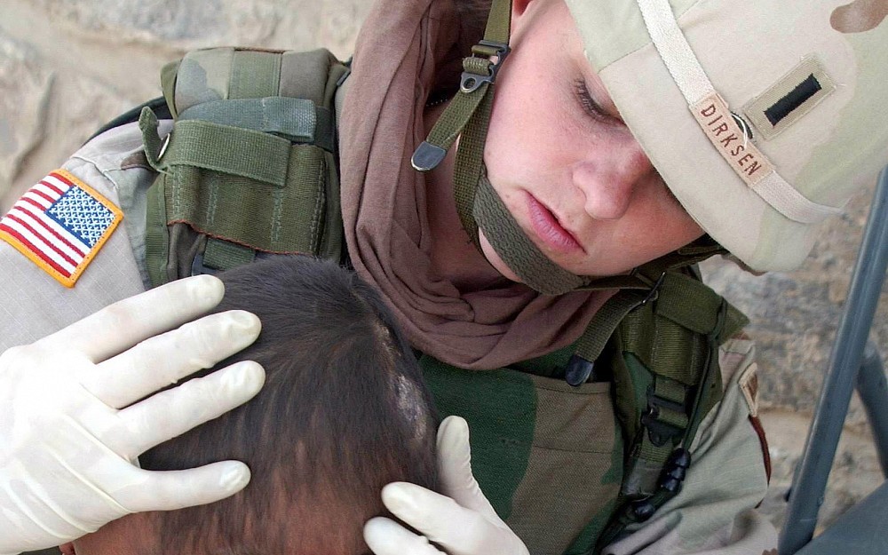Registered nurse 1st Lt. Dawn Dirksen of the 911th Forward Surgical Team checks a young girl's head in the village of Loy Karezak, Afghanistan. The 933rd surgical team will visit UC on May 10.