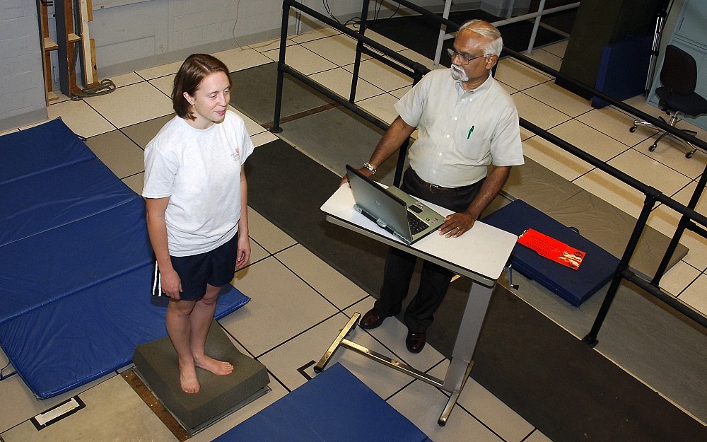 Amit Bhattacharya, PhD, tests a young woman's postural balance. 