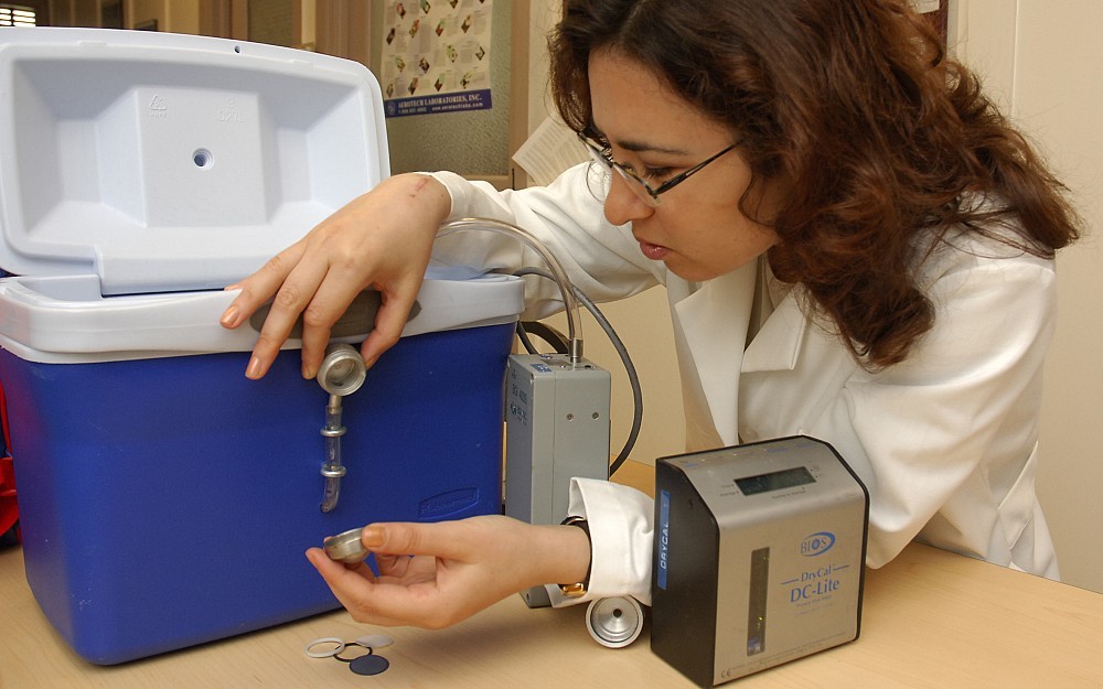 Environmental health scientist Yulia Iossifova calibrates an air sampling device used to collect fungal spores.