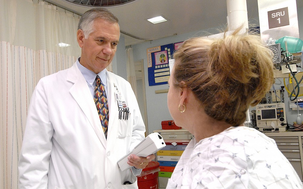 W. Brian Gibler, MD (left) with a patient in the emergency room