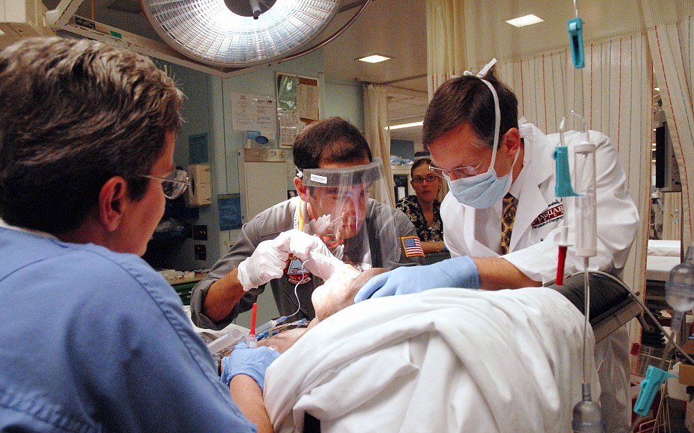 Art Pancioli, MD, (right) works with a second-year resident to stablize a patient in the emergency department.