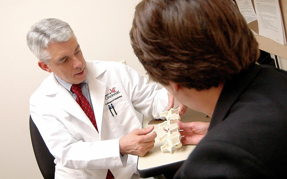 Nelson Watts, MD, explains to a patient how osteoporosis develops.
