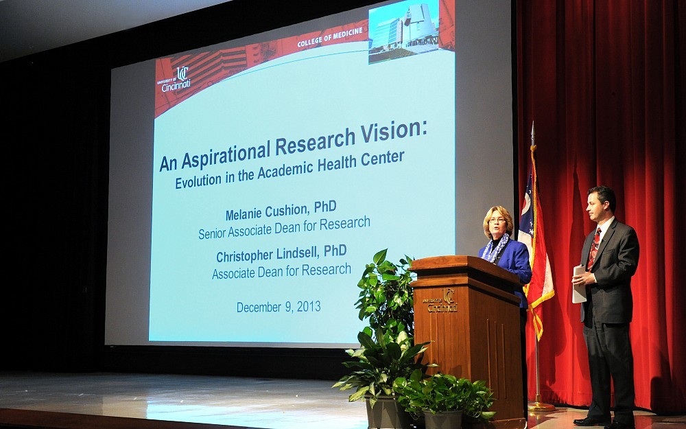 Melanie Cushion, PhD, and Christopher Lindsell, PhD, presenting on College of Medicine research Dec. 9, 2013, in Kresge Auditorium.
