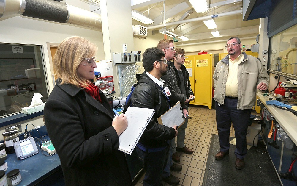 Jennie Cox takes notes as Rob Paxton leads students from the Department of Environmental Health Division of Environmental and Industrial Hygiene on a tour of the Shepherd Chemical plant in Norwood. 